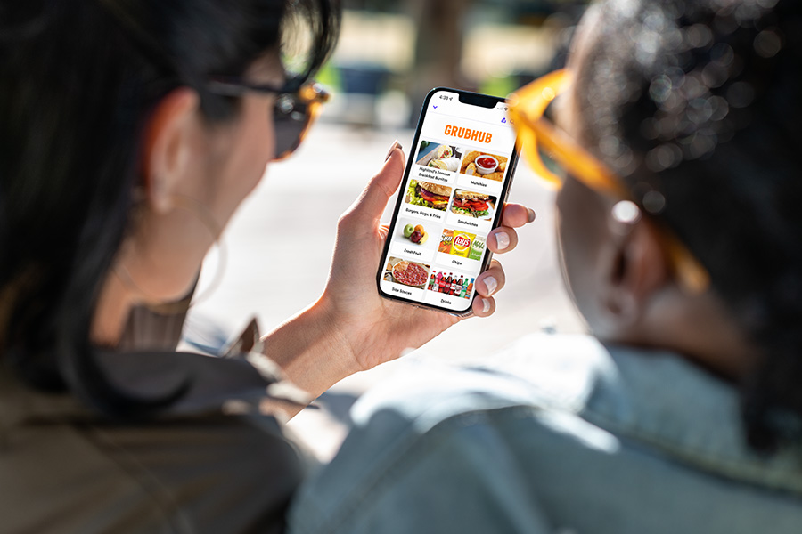 woman holding a smartphone with grubhub on screen